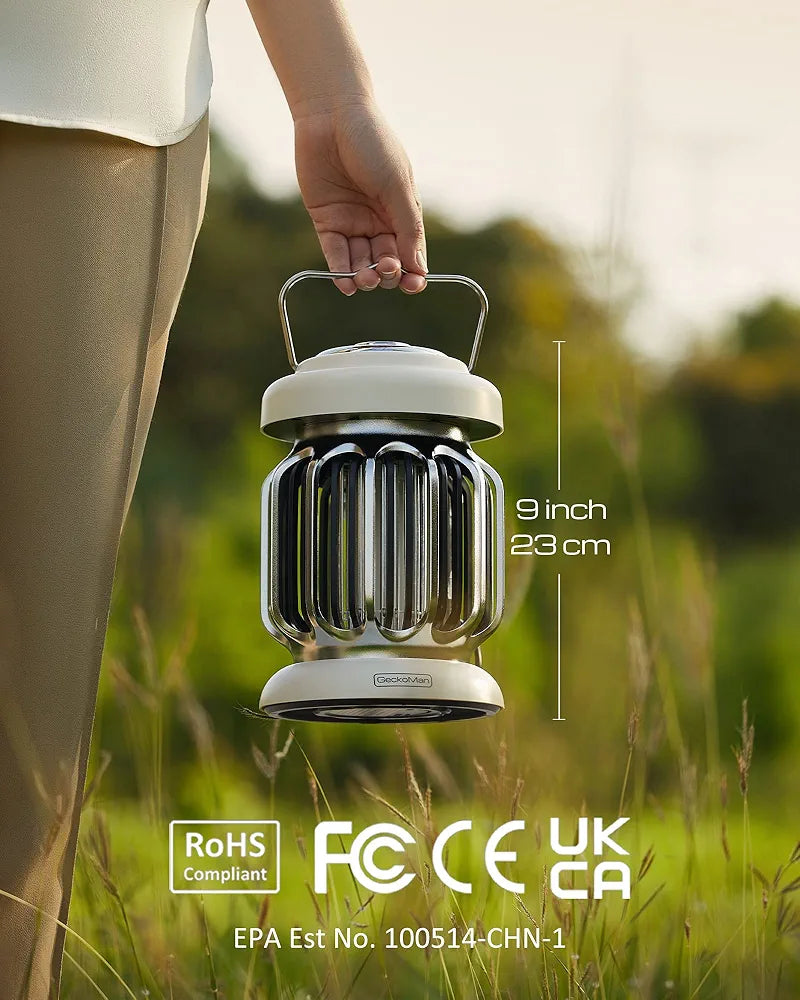 Person holding a 9-inch portable garden lantern with compliance logos, set against a grassy outdoor background.