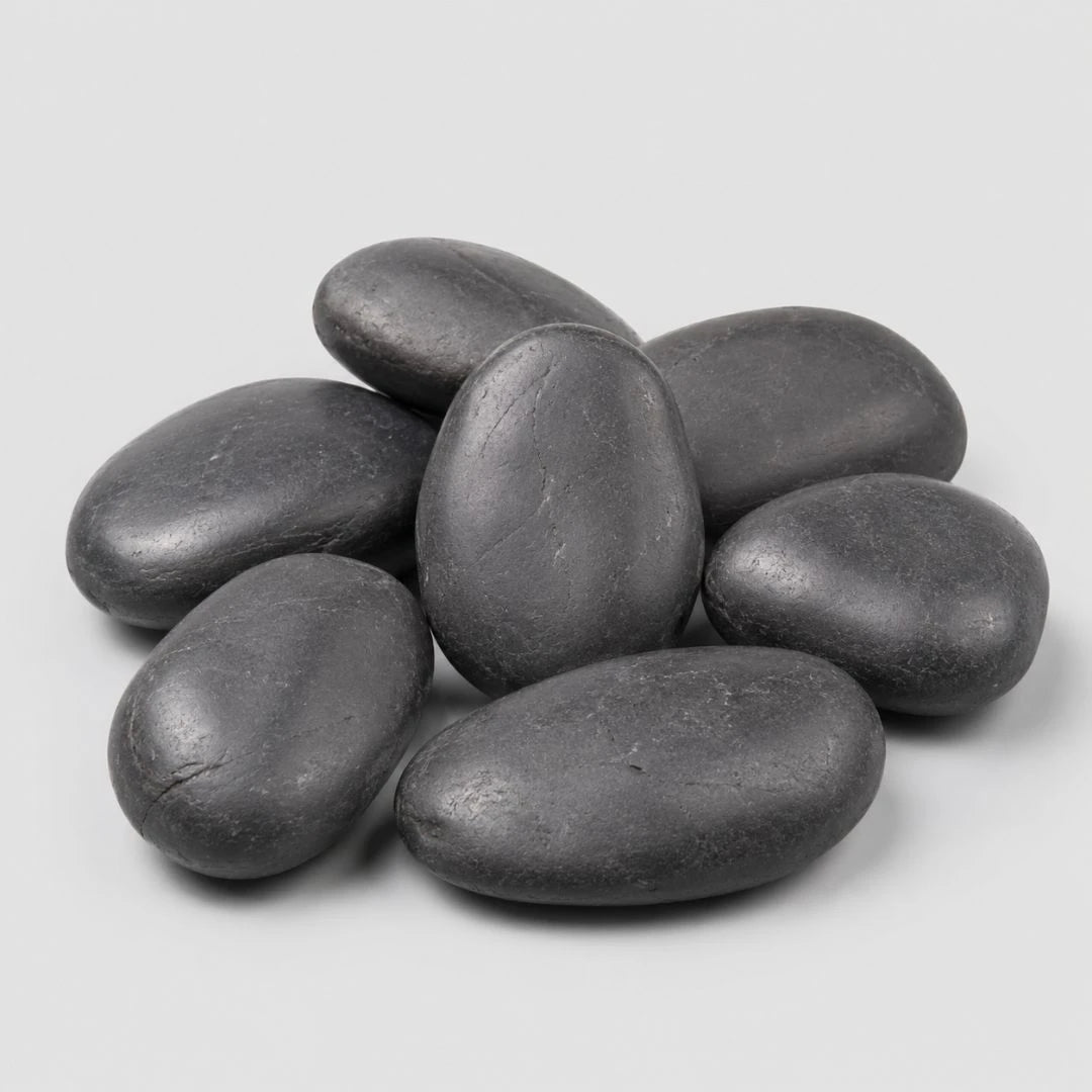 A pile of smooth, black polished pebbles stones on a light gray background.