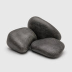 Three smooth black polished decorative stones arranged in a small pile on a light gray background.