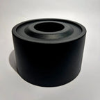 Black metal tabletop fireplace with a cylindrical design on a light background.
