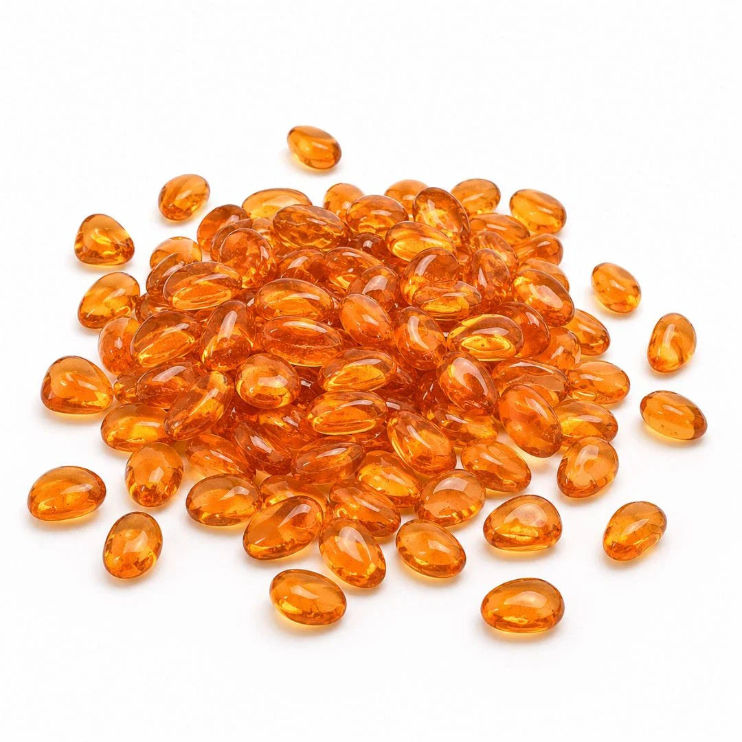 Pile of smooth, translucent orange glass pebbles on a white background.