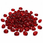 Pile of glossy red glass pebbles on a white background.