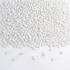 White decorative pebbles scattered across a white background, with a few stones lying on the surface in front of the pile.