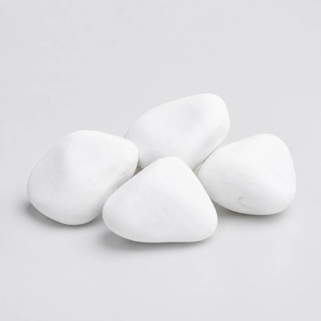 A pile of smooth, rounded white decorative stones in medium size on a plain light gray background.