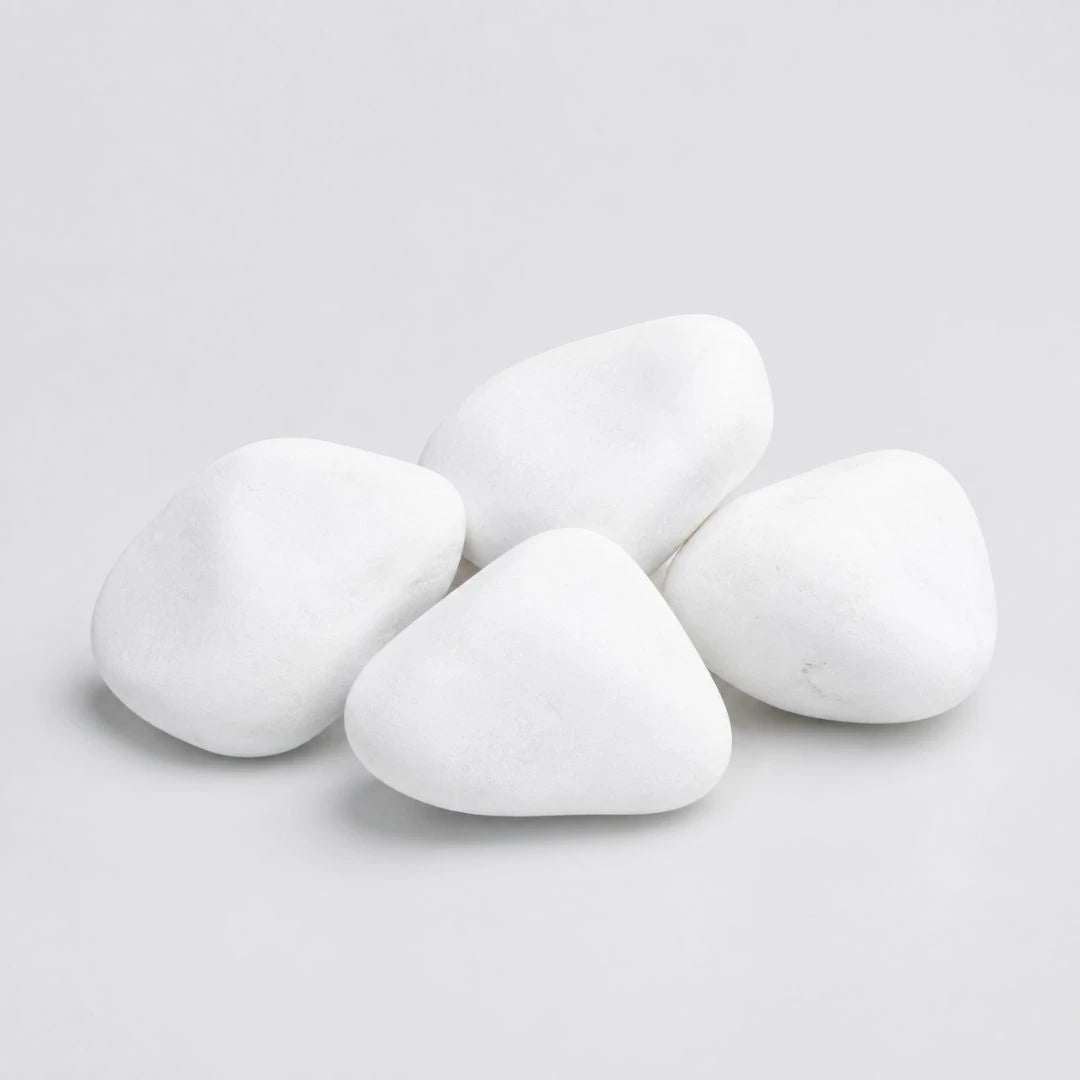 A pile of smooth, rounded white decorative stones in medium size on a plain light gray background.