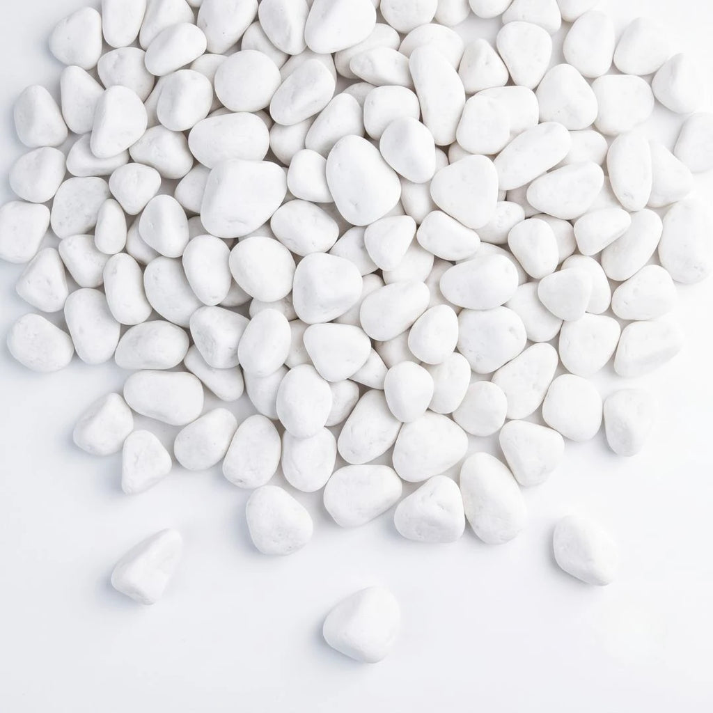 White decorative pebbles piled on a clean white background, with a few scattered around the bottom.
