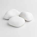 A pile of smooth, rounded white decorative stones in largest size cobbles on a plain light gray background.