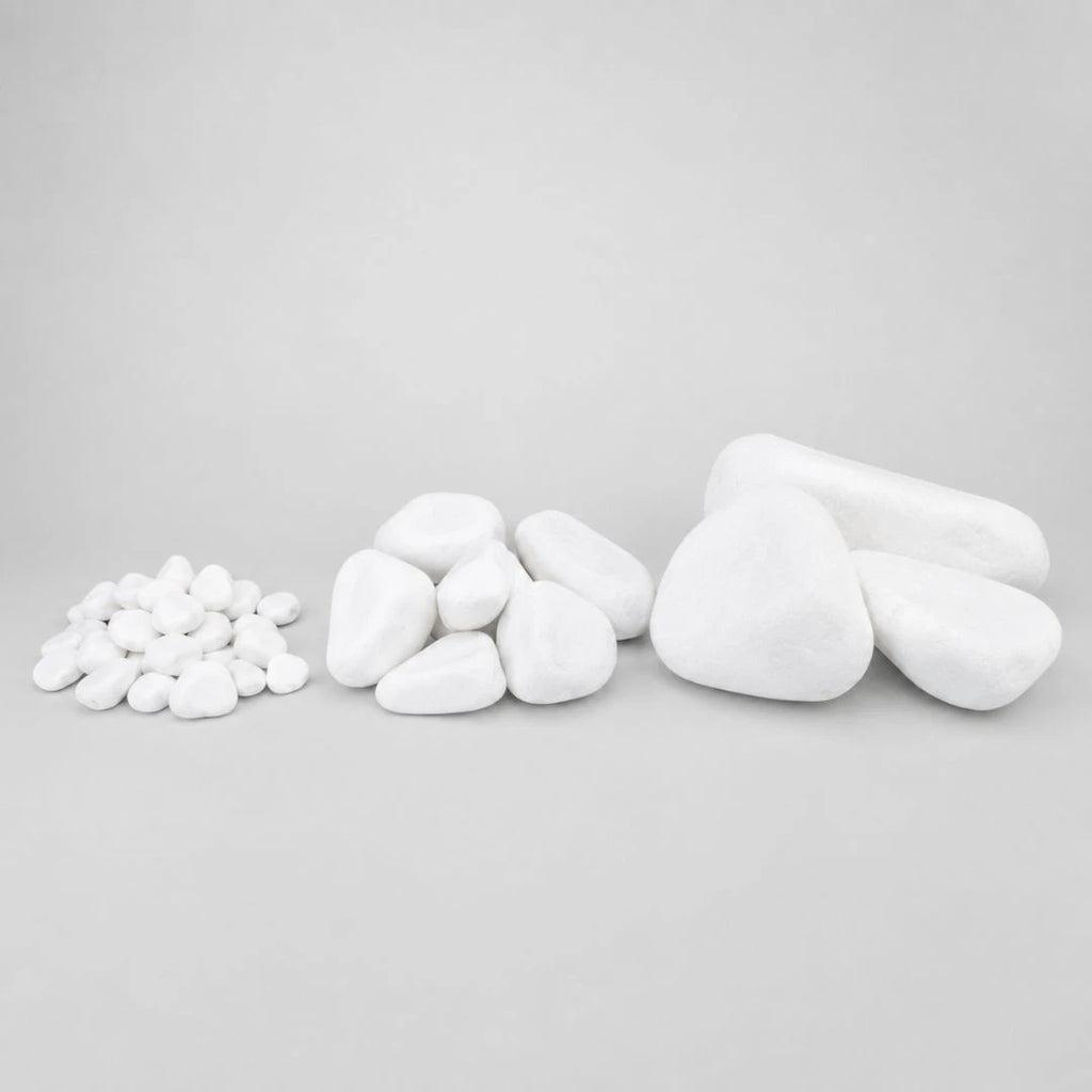 Various sizes of pure white pebbles displayed on a light gray seamless background.