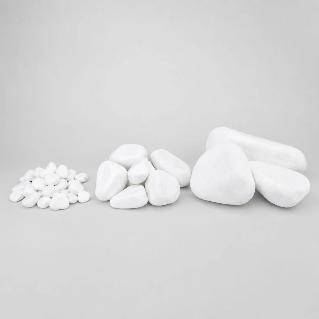 Various sizes of pure white pebbles arranged in groups on a light gray seamless background.